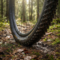 Continental Cross King II Reifen 26x2.00 schwarz faltbar auf schlammigem Waldweg im Sonnenlicht.