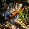 Orange Race Face Atlas MTB Downhill Kurbel mit blauem Kettenblatt auf Dirt-Trail. Robuste Power.