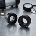 Zwei schwarze Mijnen Pieper Ersatzgummi KFZ-Seite auf Metall mit Manometer.