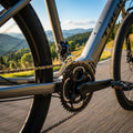 Shimano Deore Umwerfer am Antrieb eines Trek Pedelecs mit Kurbel und Kette auf einer Bergstraße.