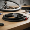 Zefal Pumpenschlauch mit Z-Switch Kopf Air1-3 Malamut Switch Big Shot Pro auf Werkbank, Fahrrad im Hintergrund.