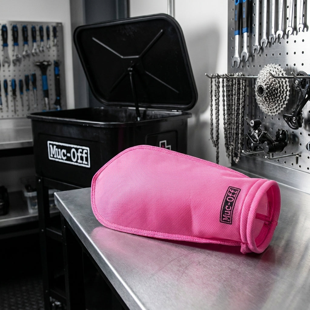 Muc-Off pinker Socket Filter für 40L Teilewaschbecken auf Werkbank, umgeben von Fahrradwerkzeugen.