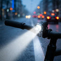 XLC Batterie Scheinwerfer CL-F24 LED 10/25Lux mit Reflektor am Lenker beleuchtet nasse Straße bei Nacht.