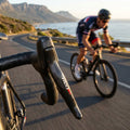 SRAM RED 11-fach Schalt-/Bremshebel rechts am Rennrad, Carbon-Design, in Aktion auf Küstenstraße.