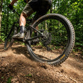 Continental Cross King II Performance Faltreifen am Mountainbike auf staubigem Waldweg, Staub aufwirbelnd.