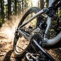 SHIMANO SLX FD-M7100 Umwerfer am Mountainbike auf staubigem Waldweg, bietet präzise Schaltperformance.