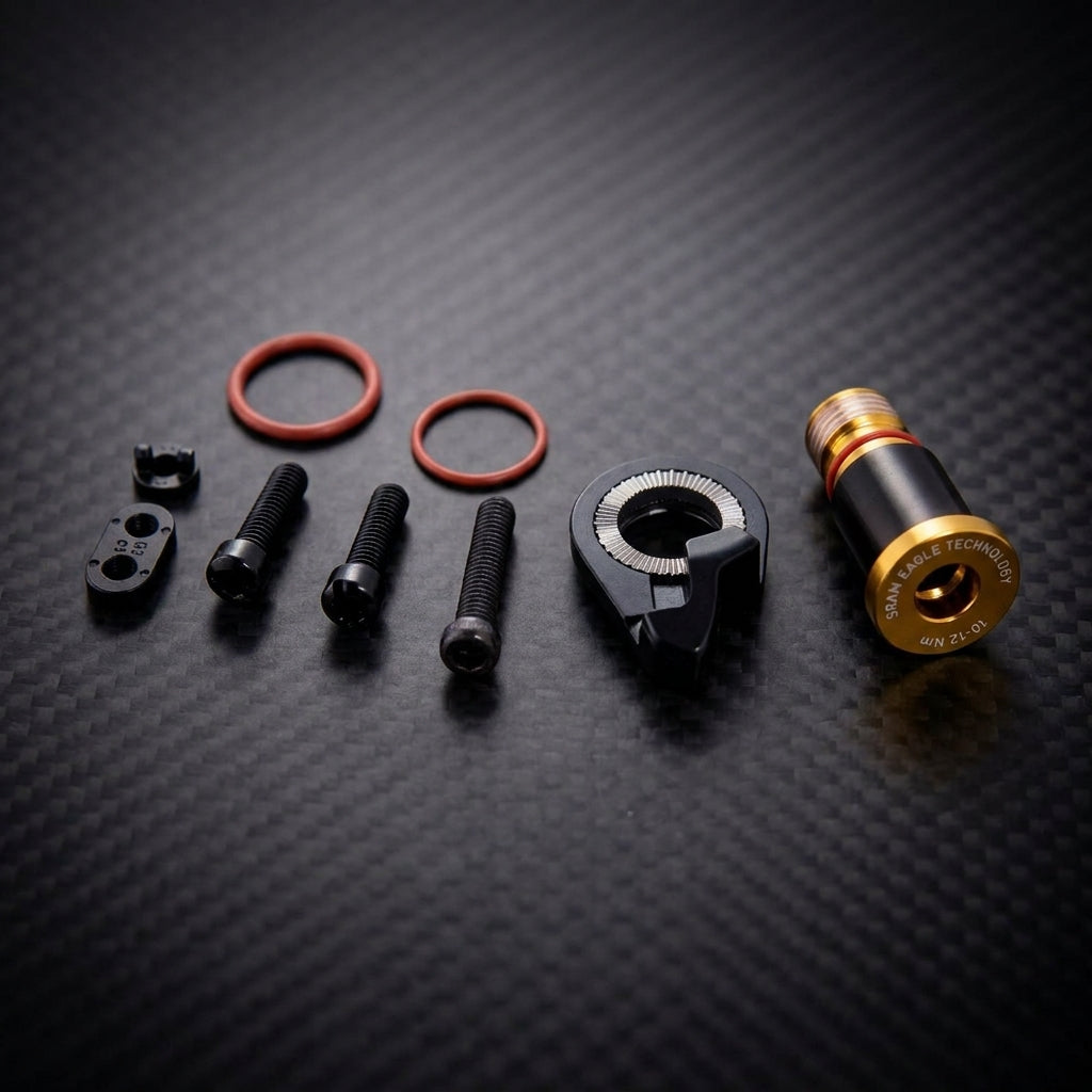 SRAM XX1 Eagle Gold Schraubenset für Schaltwerk: Befestigungs- und Einstellschrauben auf schwarzem Carbonhintergrund.