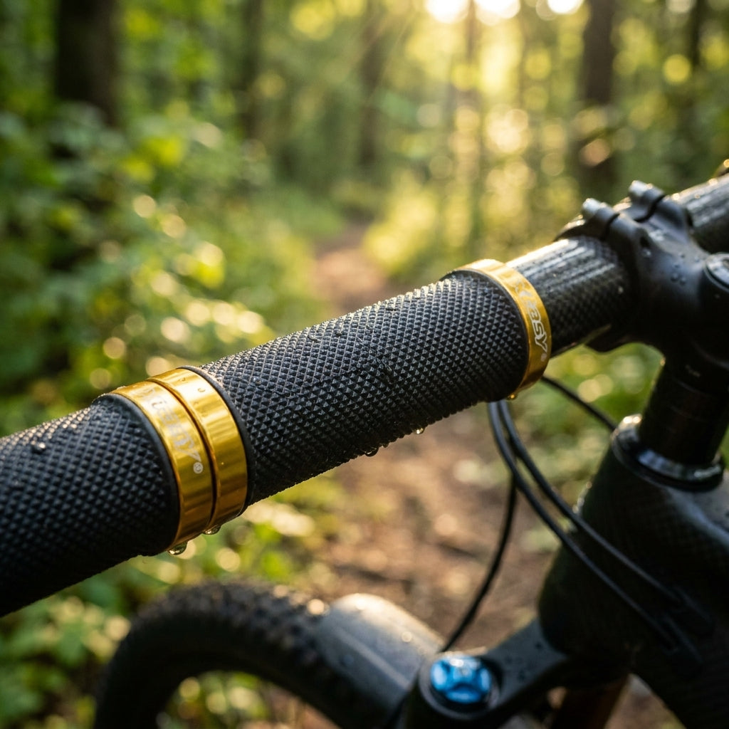 Ergotec MTB-Griffe schwarz mit goldener Klemmung am Fahrradlenker im Wald, mit Wassertropfen.
