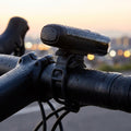 CATEYE Fahrradlicht mit kurzem 10 cm Spanngummi-Band am Lenker, sicher befestigt und wetterfest mit Regentropfen.