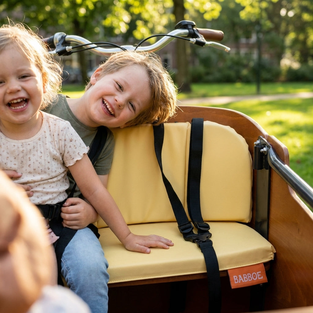 Lachende Kinder im Babboe Lastenrad mit dem Kissenset Mellow Yellow für Go.