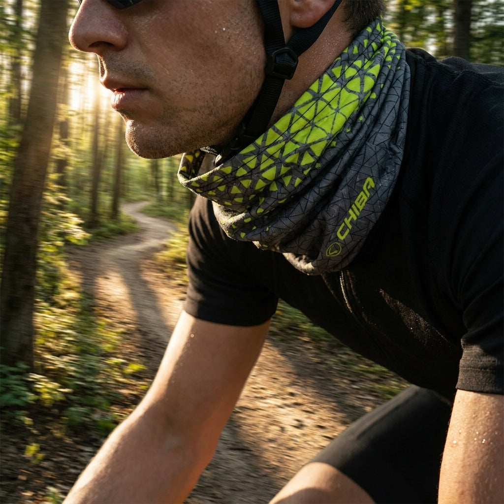 CHIBA Multifunktionstuch dunkelgrau neongelb, leicht & elastisch, getragen von Radfahrer im sonnigen Wald.