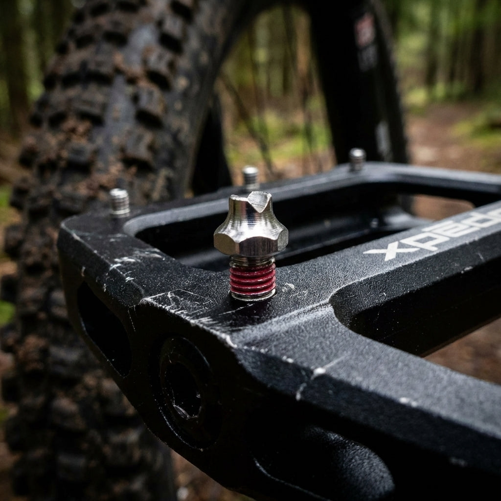 Xpedo Pinset Twin-Type Pedalpin mit 4,5mm Gewinde in schwarzem Mountainbike-Pedal auf Waldweg.