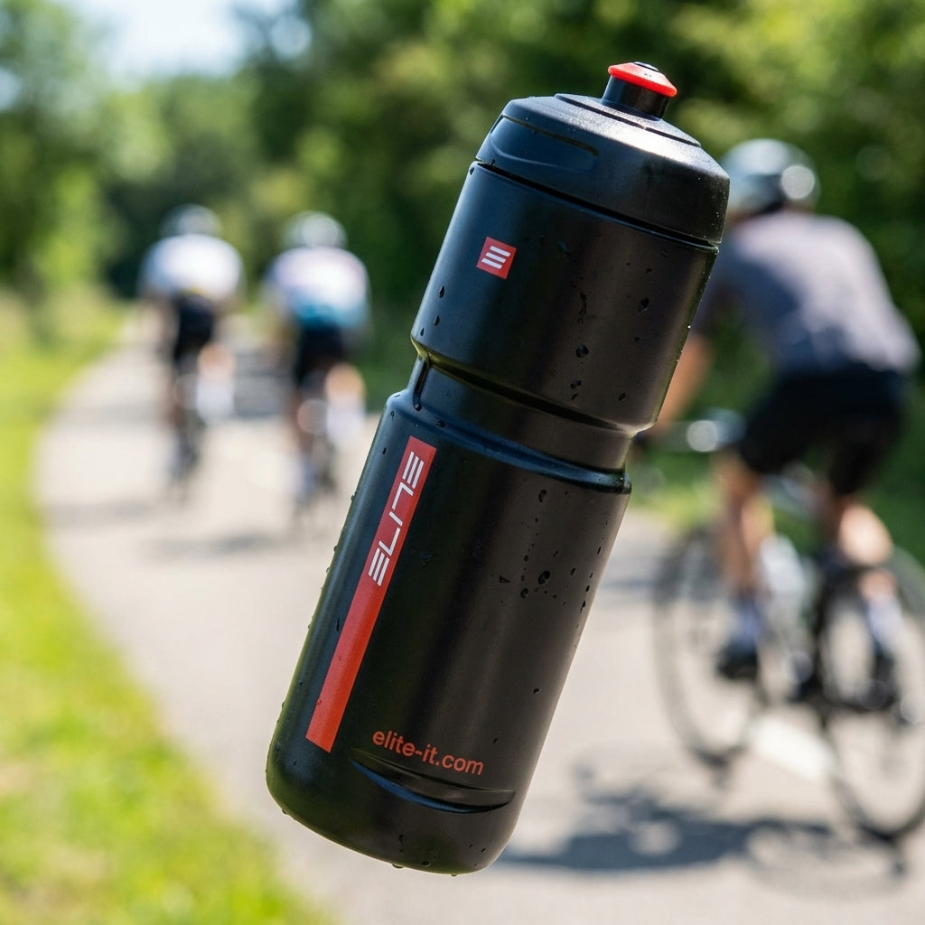 Elite Trinkflasche Superloli 800ml schwarz für Fahrrad, Wassertropfen, Radfahrer auf grünem Weg im Hintergrund.