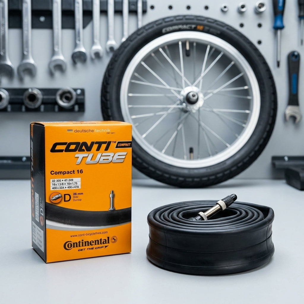 Continental Fahrradschlauch Conti Compact 16, 16 Zoll, DV 26mm, mit Verpackung und Werkstatt-Hintergrund.