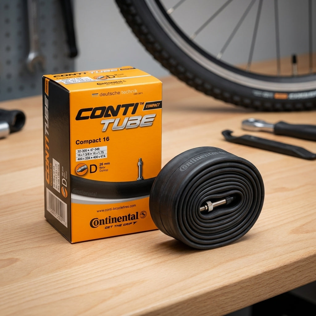 Continental Conti Compact 16 Fahrradschlauch 16 Zoll, Dunlop Ventil 26mm, mit Verpackung auf Holztisch.