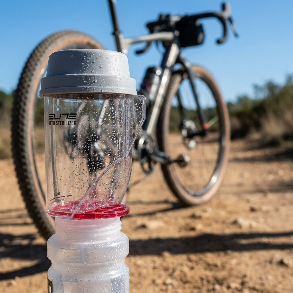 ELITE NETO Sterilisator für Kunststoff Trinkflaschen, Flaschenreiniger in Gebrauch, mit Fahrrad im Hintergrund auf Feldweg.