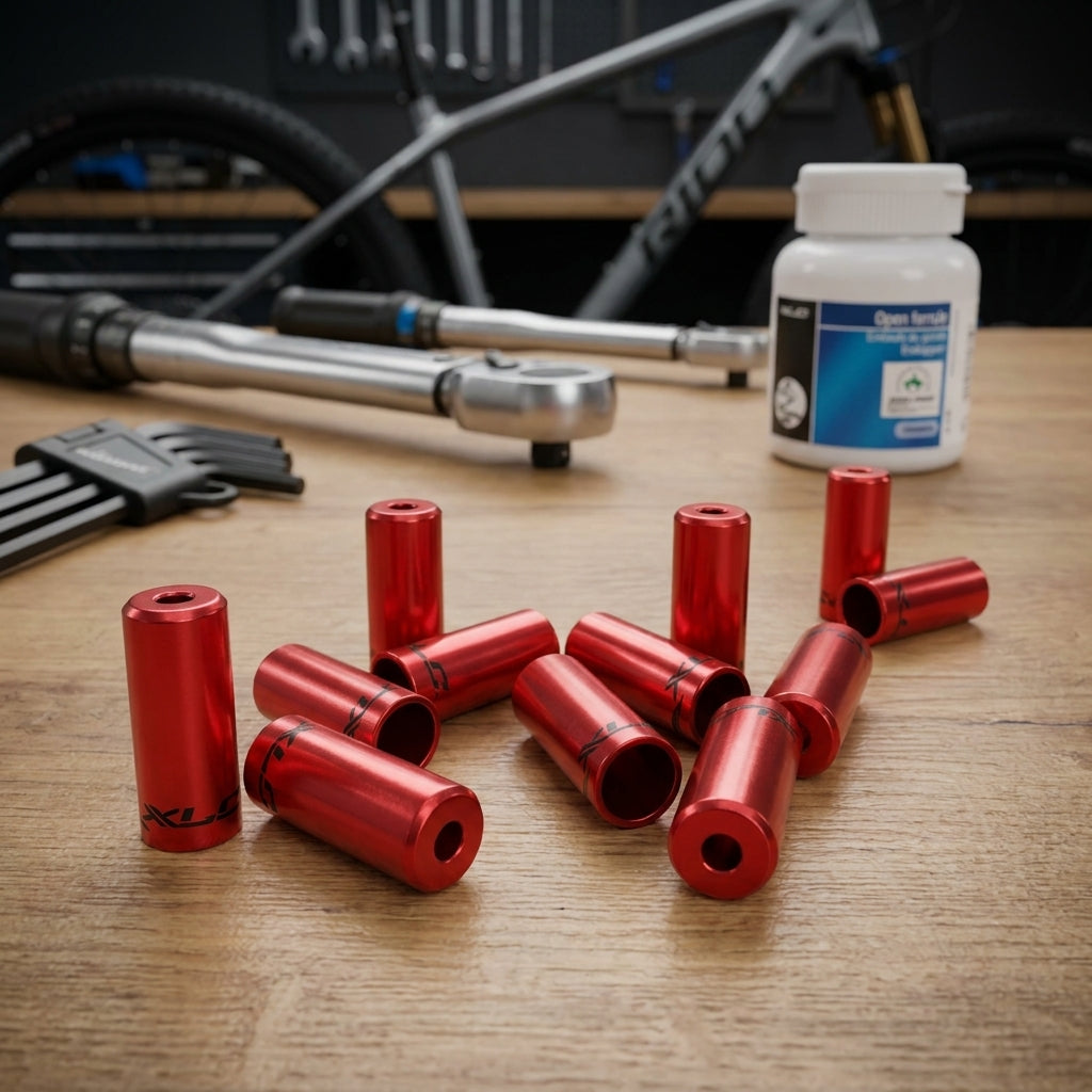 Rote XLC Endkappen BR-X10 (5,0mm) für Bremsaussenhüllen, auf Holztisch mit Fahrradwerkzeug und Fahrrad im Hintergrund.