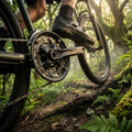 Robuste SHIMANO FC-M210-3 3-fach Kurbelgarnitur am Mountainbike auf nassem Waldweg im Einsatz.