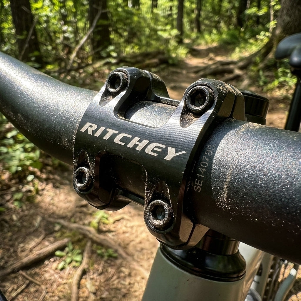 Robuste Ritchey WCS Trail Vorbau-Lenkerkappe am Fahrradlenker auf einem staubigen MTB-Pfad im Wald.