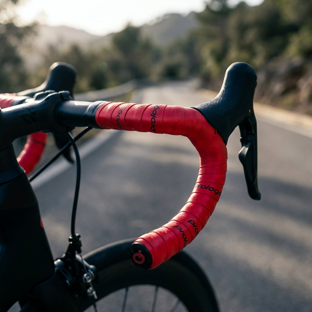 Prologo Lenkerband Skintouch rot am Rennrad-Lenker. Griffiges, rotes Fahrradlenkerband mit Wassertropfen auf der Straße.