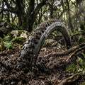 Mountainbike-Reifen Michelin Force Access Line 29x2.60" in einem schlammigen Waldweg, spritzender Dreck.