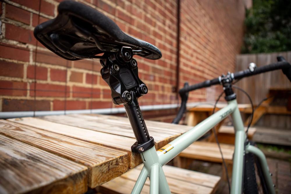 Cane Creek Thudbuster G4 ST Sattelstütze, schwarz, mit Parallelogramm-Mechanik an einem hellgrünen Fahrrad.