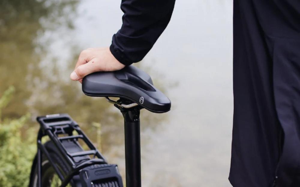 Selle Royal On Open Athletic Unisex Fahrradsattel, schwarz, mit Hand darauf, im Freien am Wasser.