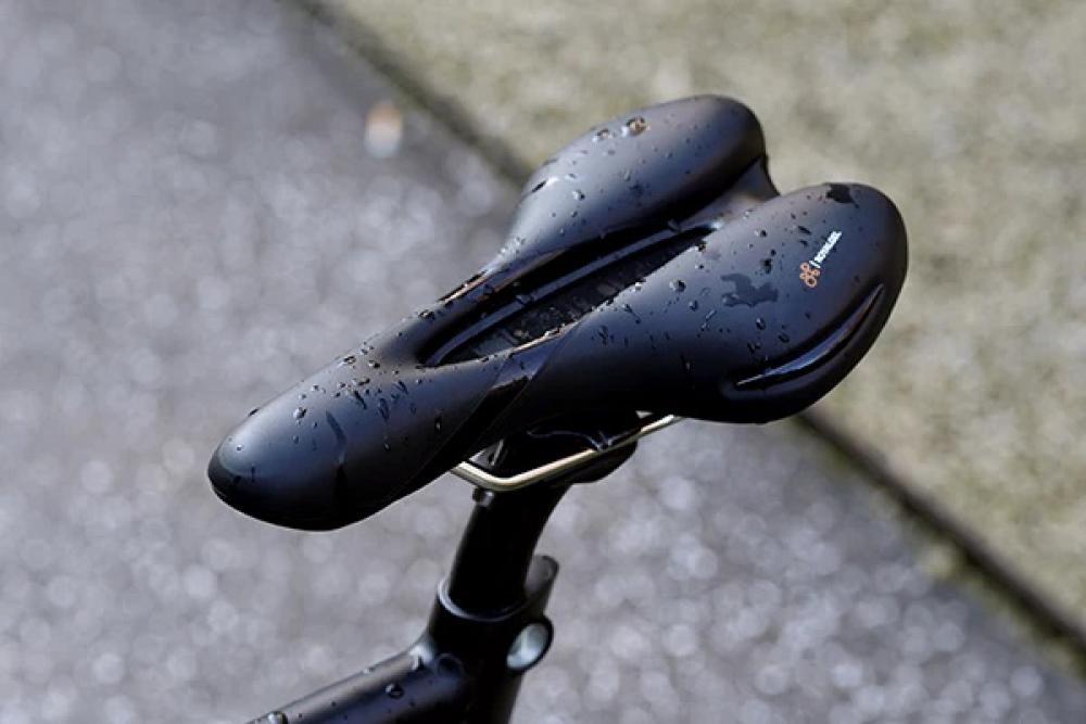 Selle Royal Respiro Athletic Unisex Fahrradsattel, schwarz, nass mit Regentropfen auf einem Fahrrad.