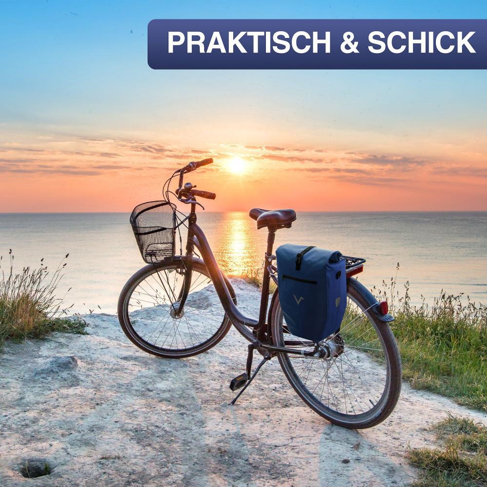 Valkental ValkBasic blaue wasserdichte 20L Gepäckträgertasche am Fahrrad bei Sonnenuntergang am Meer.