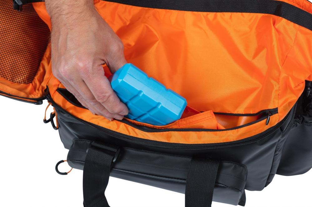 Basil Miles Tarpaulin XL Pro MIK 2.0 Gepäckträgertasche (schwarz/orange). Hand verstaut Gegenstand im orangefarbenen Innenfac