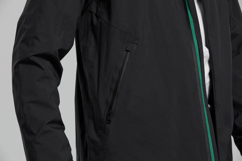 Basil Skane Herren Regenjacke schwarz, wasserdicht, atmungsaktiv, Reißverschluss mit grüner Zierleiste und Tasche.