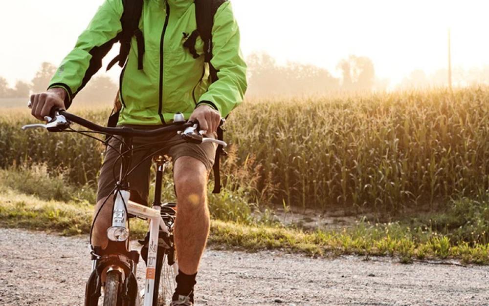 Radfahrer in grüner Jacke auf einem Fahrrad mit Selle Royal Lookin Evo Athletic Sattel auf Feldweg.