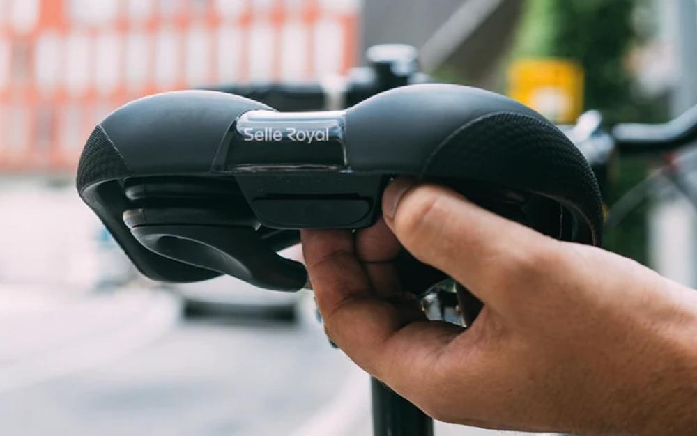 Nahaufnahme: Hand betätigt schwarzen Selle Royal Fahrradsattel für City-Komfort.