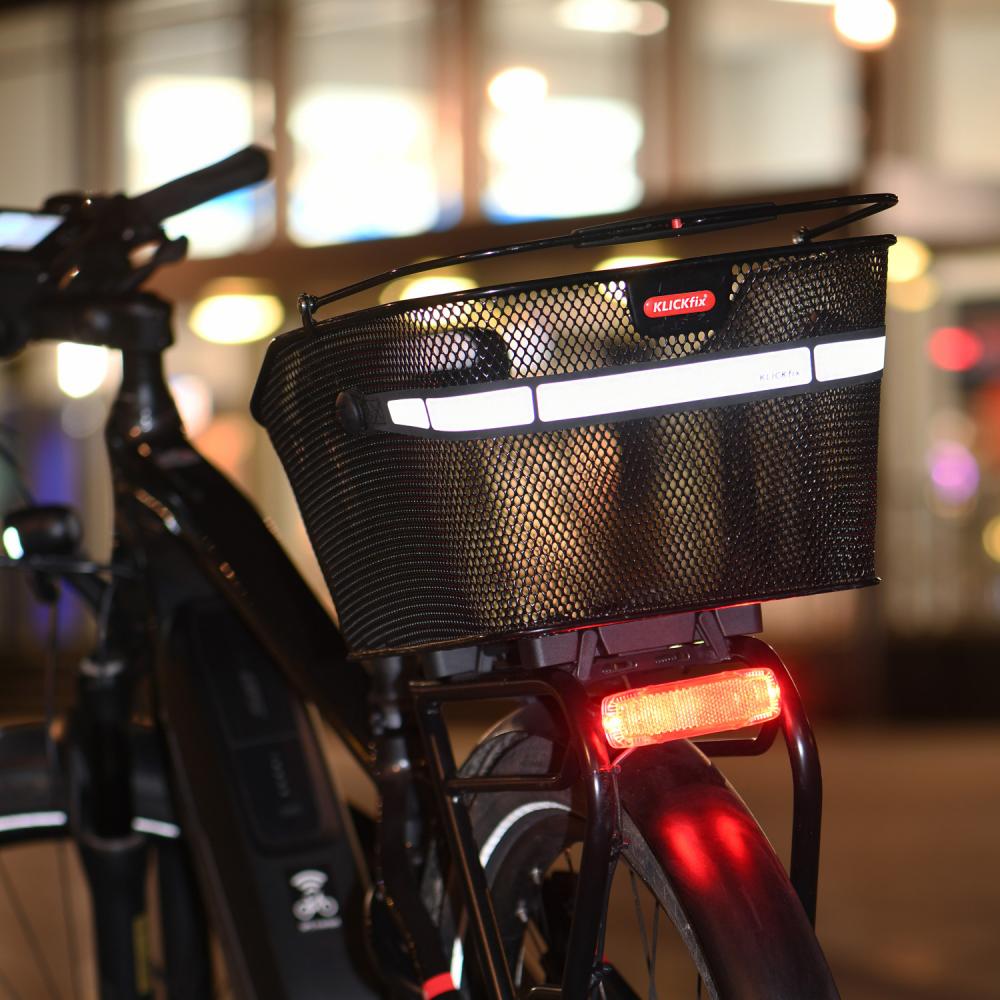 Klickfix Hinterradkorb City Racktime schwarz am Fahrrad bei Nacht mit Reflektoren und Rücklicht.