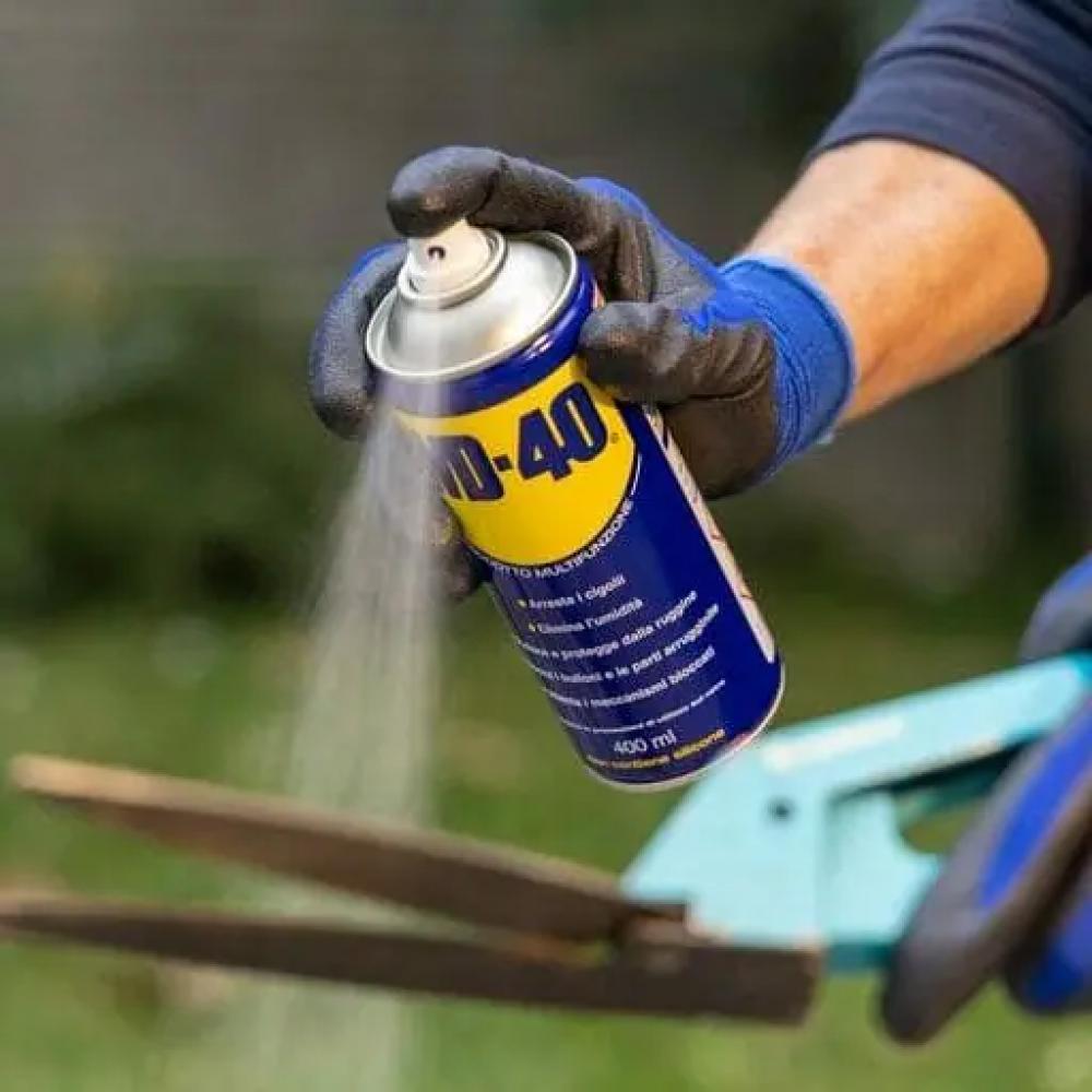 WD-40 Classic 100 ml Multifunktionsöl zur Schmierung und zum Rostschutz wird auf eine Gartenschere gesprüht.