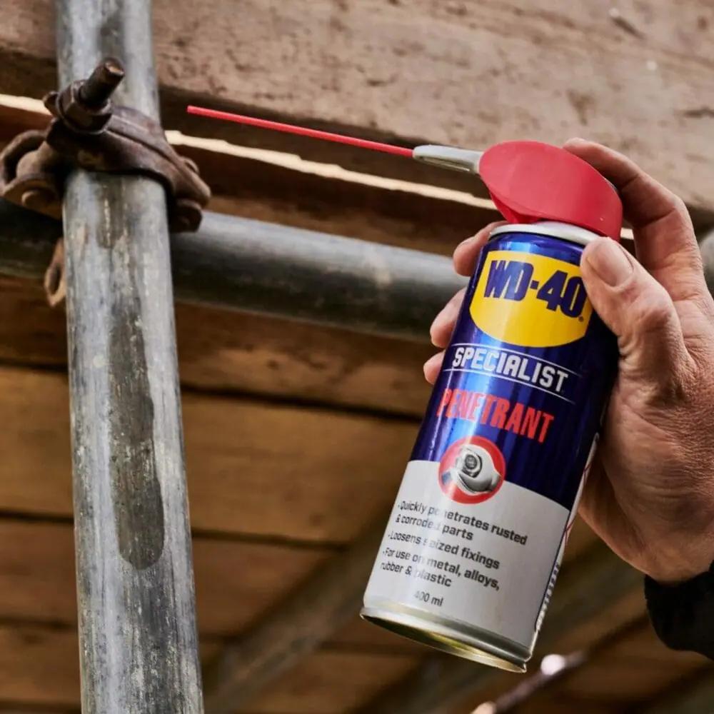 WD-40 Rostlöser 400 ml Spraydose löst Rost an einer festsitzenden Schraube an einem Metallrohr.