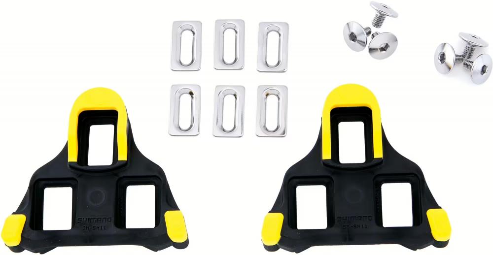 Shimano SM-SH11 SPD-SL Pedalplatten in Gelb mit Befestigungsschrauben und Unterlegscheiben auf weißem Hintergrund.