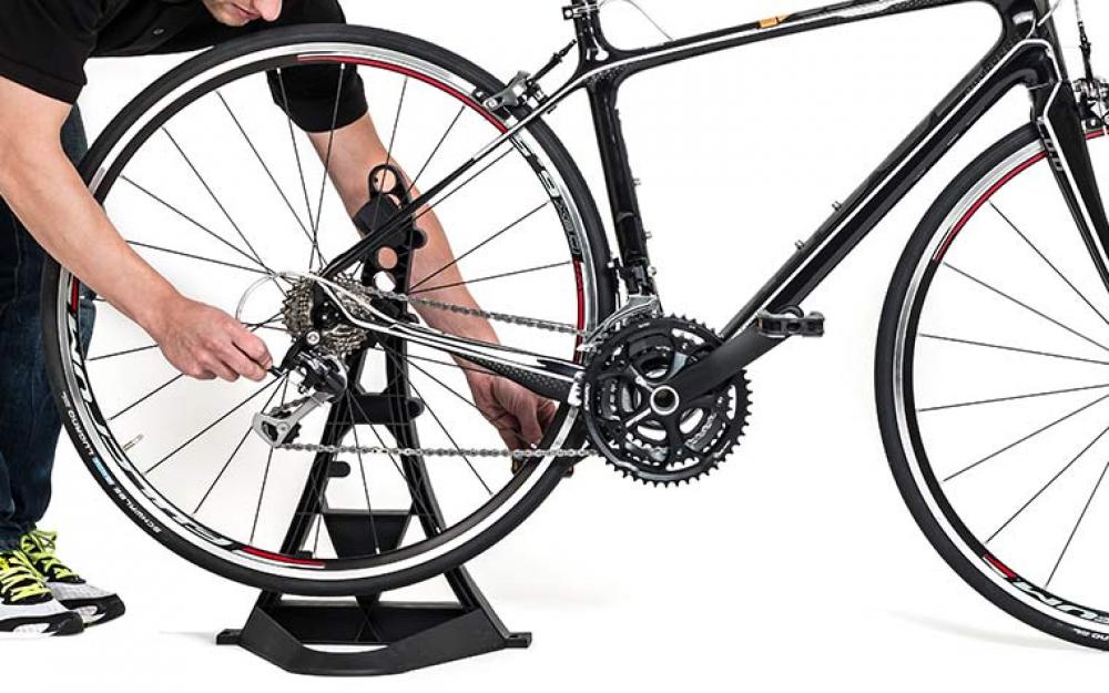Hebie Fahrradständer: Schwarzer Montageständer hält Rennrad zur Wartung des Hinterrads.