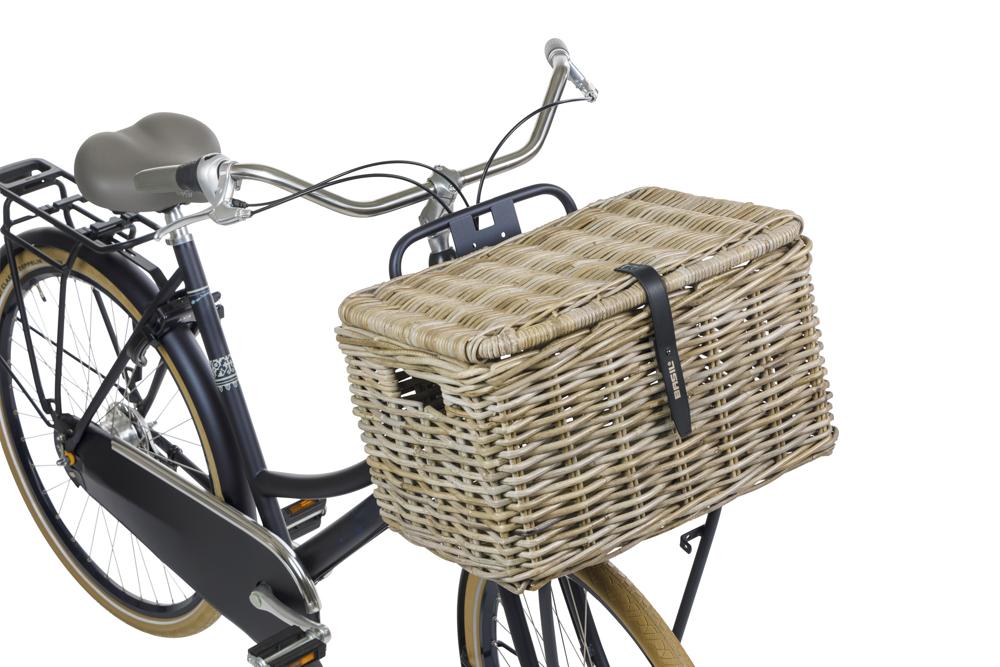 Grauer Basil Dax L Rattan-Vorderradkorb mit Deckel, grob geflochten, an einem Fahrrad montiert.