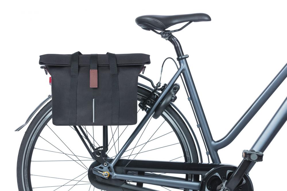 Schwarze Basil City MIK 2.0-KF-Hook Fahrradtasche am Gepäckträger eines grauen Fahrrads, wasserabweisend, mit Reflektor.
