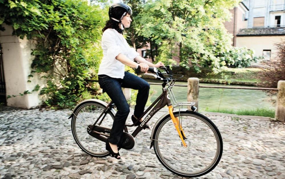 Frau fährt Fahrrad mit schwarzem Selle Royal Sattel Freeway Fit Classic entspannt auf Kopfsteinpflaster.