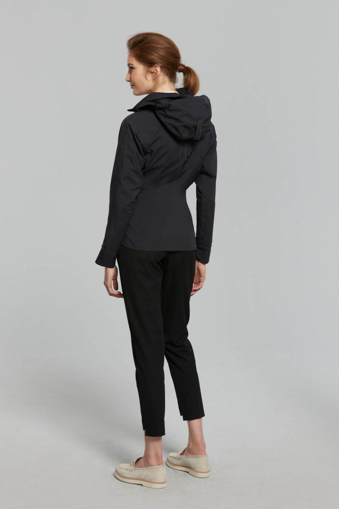 Frau trägt schwarze Basil Skane Damen Regenjacke mit tailliertem Schnitt, wasserdicht und atmungsaktiv.