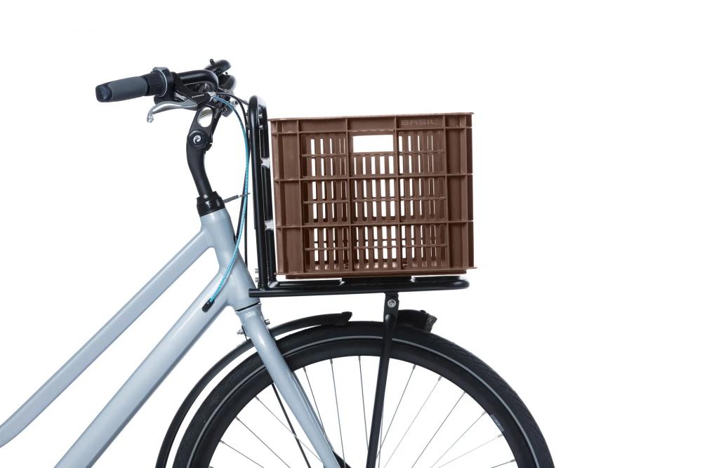 Braune Basil Crate L Fahrradkiste aus recyceltem Kunststoff auf grauem Fahrrad mit Frontgepäckträger.