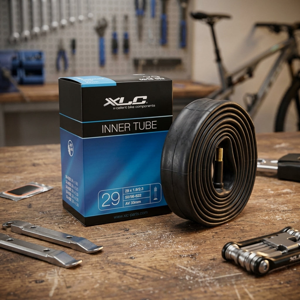 XLC Fahrradschlauch 29 x 1.9/2.3 (50/56-622) AV 34 mm in Box und gerollt auf Werkbank mit Fahrradzubehör.