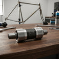 SHIMANO UN300 BSA Innenlager 73/122,5 mm auf Holzwerkbank mit Fahrradrahmen und Werkzeug.