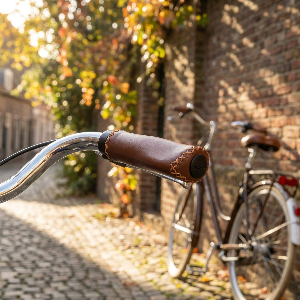 Braune XLC GR-G11 Fahrradgriffe in Lederoptik auf Chromlenker, Fahrrad im Herbst an Ziegelwand auf Kopfsteinpflaster.