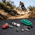 SRAM Maven Bremshebel-Innenleben Einzelteile mit Mountainbiker im Sprung auf staubiger Strecke.