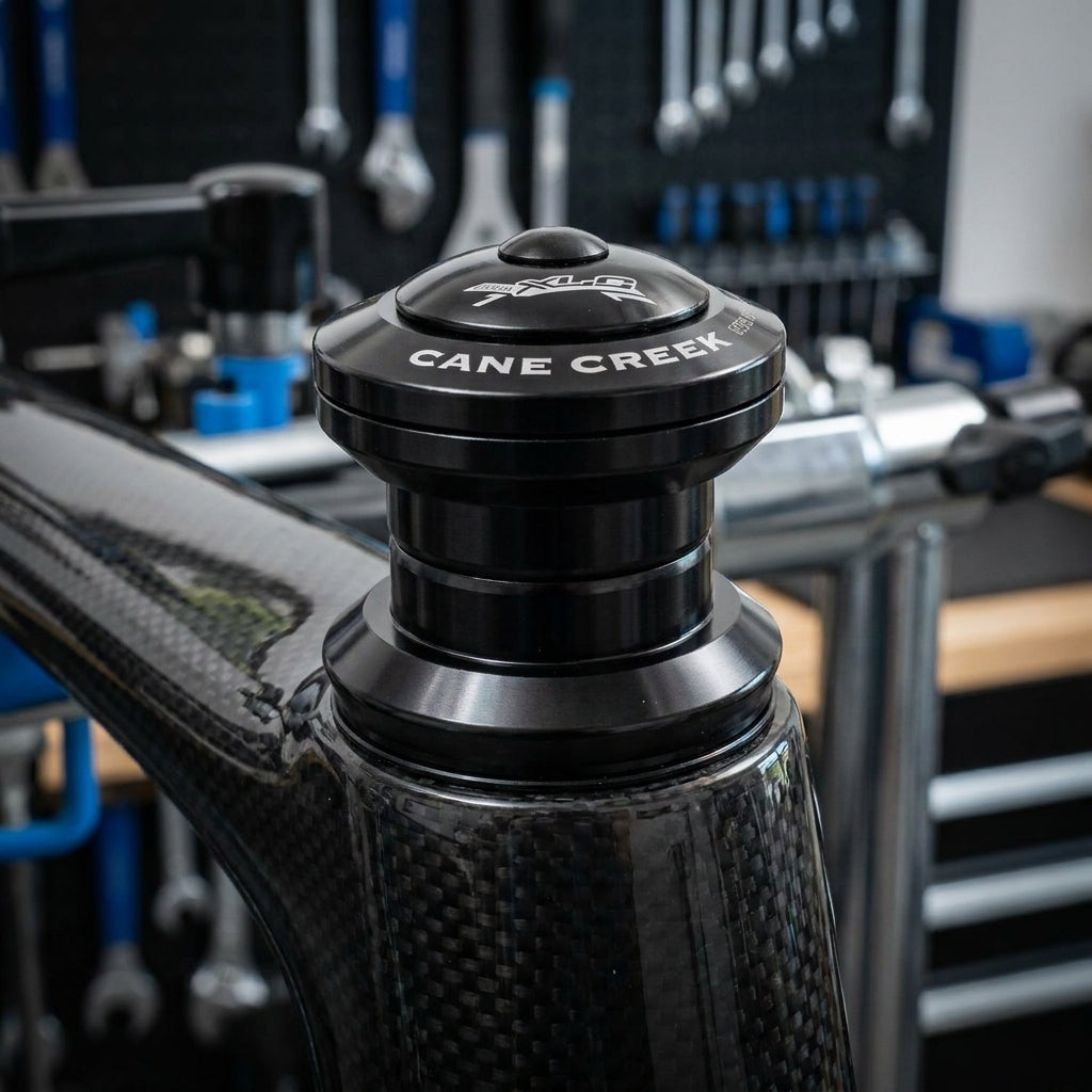 Schwarzer XLC Comp A-Head-Steuersatz HS-A08 auf glänzendem Carbon-Fahrradrahmen montiert.