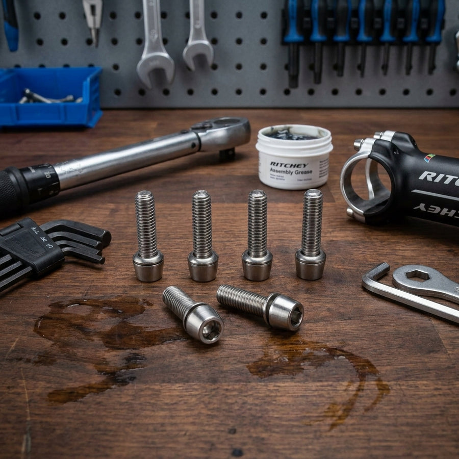 6 Ritchey WCS-Comp 4Axis Edelstahl-Vorbau-Schrauben, silber, mit Werkzeug und Fahrradvorbau auf Holztisch.