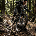 RockShox Reba RL Federgabel am Mountainbike in Action auf schlammigem Waldtrail mit Spritzern.
